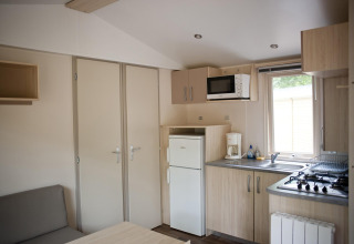 Keuken en woonkamer in een Mobile home Cottage glamping accommodatie met moderne apparatuur.