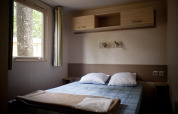 Indvendig visning af et soveværelse i et mobilhjem, glamping indkvartering, med dobbeltseng og vindue.