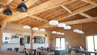 Luminoso comedor revestido en madera con lámparas modernas en Village Huttopia Lanmary, Nouvelle-Aquitania, Francia.