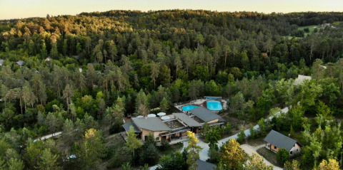 Vista aérea del Village Huttopia Lanmary, un parque de vacaciones rodeado de bosque en Nouvelle-Aquitaine, Francia.