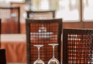 Table dressée pour deux au restaurant du Huttopia Parque de Doñana, Andalousie, Espagne, éclairée par le soleil.