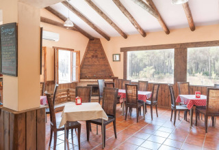 Helles, rustikales Restaurant mit Holzbalkendecke und großen Fenstern im Huttopia Parque de Doñana, Andalusien.