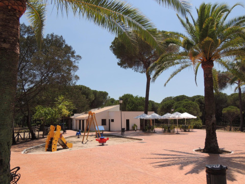 Parque infantil y área de cafetería exterior en Huttopia Parque de Doñana, parque vacacional en Andalucía, España.