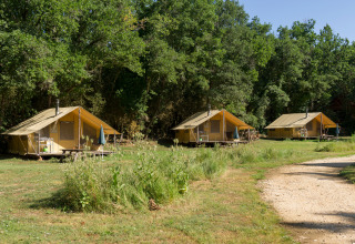 Trois tentes de glamping près d’une clairière au Village Huttopia Sud-Ardèche, Auvergne-Rhône-Alpes, France.