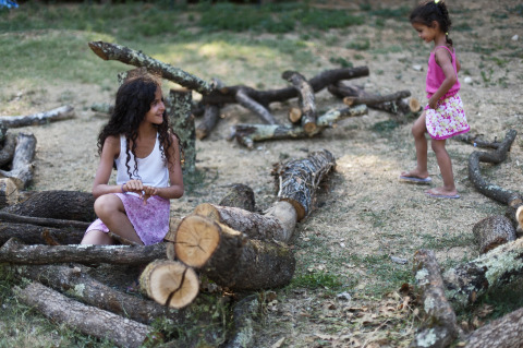 Dos niñas juegan entre troncos en el complejo turístico Village Huttopia Sud-Ardèche, en Auvergne-Rhône-Alpes, Francia.