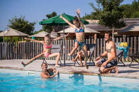 Gezin springt in het zwembad van Village Huttopia Pays de Condrieu, Auvergne-Rhône-Alpes, Frankrijk.