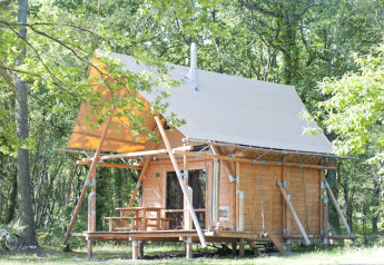 Tenda safari Cahutte al Village Huttopia Lac de Rillé, Francia, immersa nel verde della foresta.