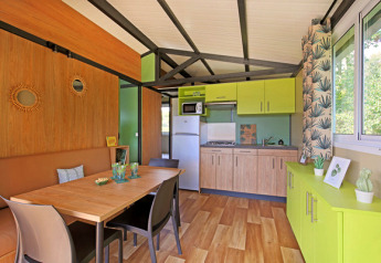 Vista interna dello Chalet Evasion al Camping de Lyon con cucina luminosa e zona pranzo.