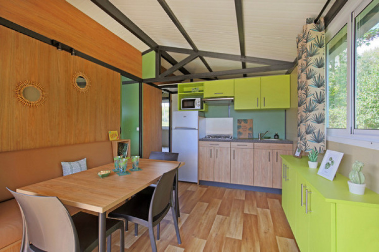 Vista interior del Chalet Evasion en Camping de Lyon, con cocina luminosa y zona de comedor.