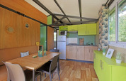 Vista interna dello Chalet Evasion al Camping de Lyon con cucina luminosa e zona pranzo.