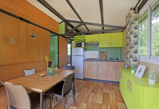 Vista interior del Chalet Evasion en Camping de Lyon, con cocina luminosa y zona de comedor.
