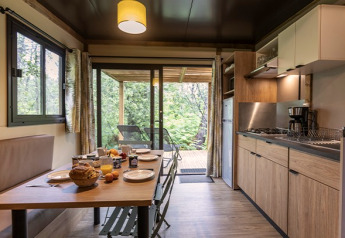 Moderne Küche und Essbereich im Chalet Ottawa auf dem Camping de Lyon mit Blick auf die Terrasse in Frankreich.