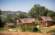 Cuatro tiendas tipo safari llamadas Cahutte en Huttopia Pays de Cordes sur Ciel, Francia, rodeadas de naturaleza.