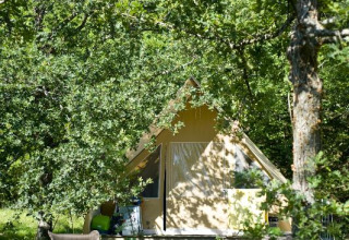 Safari-Zelt Canadienne im Village Huttopia Dieulefit, Frankreich, eingebettet in eine grüne, bewaldete Umgebung.