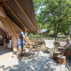 Udendørs terrasse ved en safari Tente Trappeur, hvor en familie hygger sig midt i grøn natur.