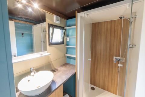 Baño moderno en Chalet Evasion con ducha, lavabo y espejo, Camping Valkenburg - Maastricht, Países Bajos.