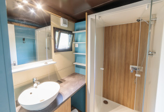Bagno moderno nello Chalet Evasion con doccia, lavabo e specchio, Camping Valkenburg - Maastricht, Paesi Bassi.
