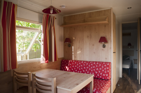 Interno accogliente di una roulotte con arredi rossi al Camping Valkenburg - Maastricht, Paesi Bassi.