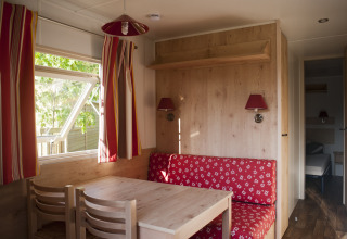 Interno accogliente di una roulotte con arredi rossi al Camping Valkenburg - Maastricht, Paesi Bassi.