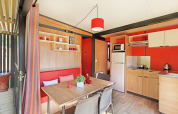 Moderne keuken en eetruimte in Chalet Evasion Vista bij Huttopia De Roos, Nederland, met rode tinten.