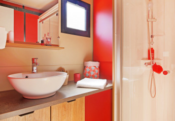 Moderne badeværelse i Chalet Evasion Vista på Huttopia De Roos, Holland, med bruser og spejl.