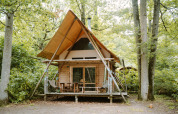 Safari-Zelt Cahutte im Huttopia De Roos in den Niederlanden, umgeben von Bäumen und Natur.