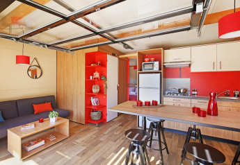 Interieur van Chalet Toronto bij Huttopia De Roos in Nederland met moderne keuken en gezellige zithoek.