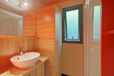 Moderne badkamer met houtdecor, waskom en matraam in Chalet Toronto, Huttopia De Roos, Nederland.