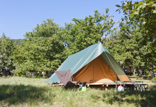 Een tipi-tent genaamd Tent Bonaventure in Village Huttopia Lanmary in Frankrijk, tussen de groene bomen.