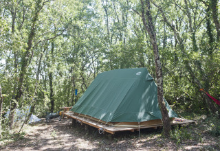 Groene Bonaventure tipi tent op houten platform in het bos bij Village Huttopia Sud-Ardèche in Frankrijk.