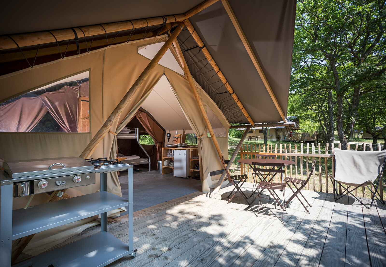 Safari Trappeur-tent bij Village Huttopia Pays de Condrieu in Frankrijk met veranda, keuken en zitplaatsen.
