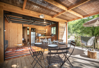Udsigt over indendørs og udendørs spiseområde i Chalet Toronto på Village Huttopia Pays de Condrieu, Frankrig.