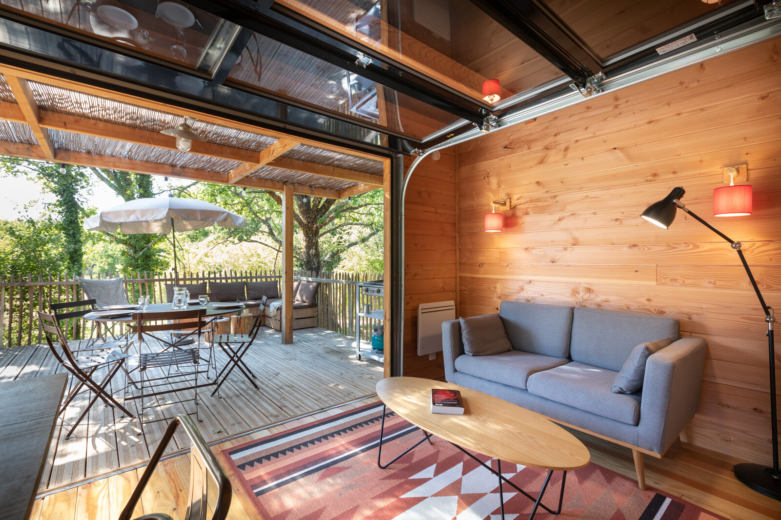 Binnen-buiten leefruimte in Chalet Toronto, Village Huttopia Pays de Condrieu, Frankrijk, met houten interieur.