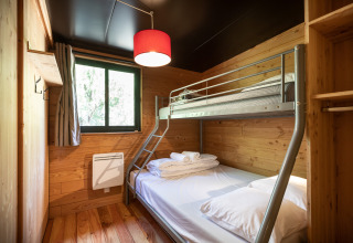 Værelse med køjeseng og træinteriør på Chalet Toronto, Village Huttopia Pays de Condrieu i Frankrig.