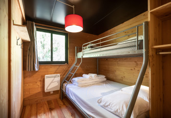 Kamer met stapelbed en houten wanden in Chalet Toronto, Village Huttopia Pays de Condrieu in Frankrijk.