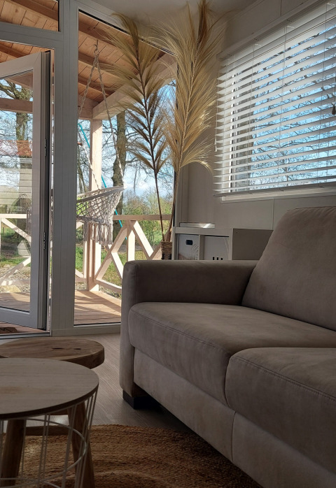 Solbelyst stue i Beach House på Beloofde Land, Holland, med udsigt til terrasse og natur udenfor.