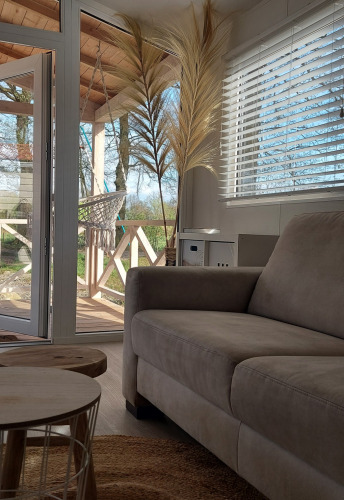 Soggiorno soleggiato al Beach House di Beloofde Land, Paesi Bassi, con vista su terrazza e natura circostante.