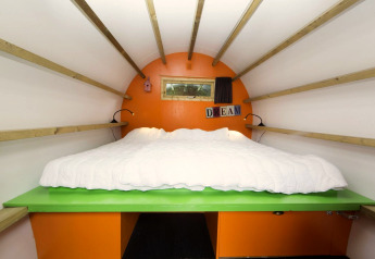 Interior view of a cozy cabin called 'Sleeping in a tree trunk' at Veluwecamping De Pampel, Netherlands.