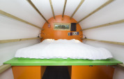 Vista interior de una acogedora cabaña llamada 'Dormir en un tronco' en Veluwecamping De Pampel, Países Bajos.