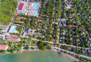 Vue aérienne du SunLodge Katsura au Camping Gasparina en Italie, avec piscines, arbres et bord du lac.