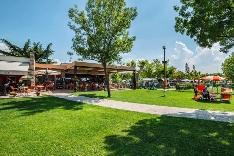 Zona exterior en SunLodge Katsura de Camping Gasparina en Italia, con césped verde y terraza soleada.