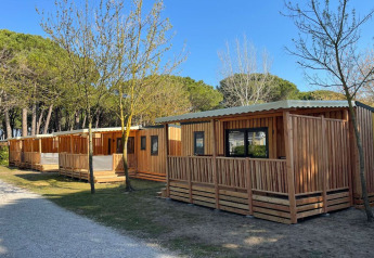 SunLodge Babul presso Camping Gasparina in Italia con lodge moderni in legno circondati da alberi e natura.
