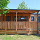 Moderne træhytte, SunLodge Sabai, ved Camping Gasparina i Italien med overdækket terrasse og grønne omgivelser.