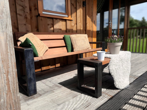 Banc en bois avec coussins sur terrasse à Ackerlodge, Ackerlodges Ruinerwold BV, Pays-Bas.