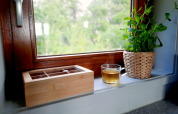 Rebord de fenêtre à Ackerlodge, Ruinerwold BV, avec tasse de thé, boîte en bois et plante en pot.
