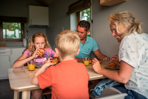 Famille prenant le petit-déjeuner avec croissants et jus d'orange à Ackerlodge, Ackerlodges Ruinerwold BV.