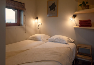Chambre double confortable à l’Ackerlodge d’Ackerlodges Ruinerwold BV, Pays-Bas, ambiance chaleureuse.