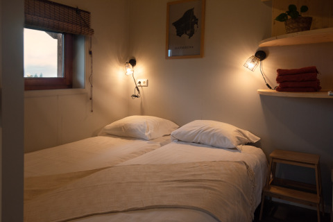 Knusse tweepersoonskamer in Ackerlodge bij Ackerlodges Ruinerwold BV, Nederland, sfeervol verlicht.