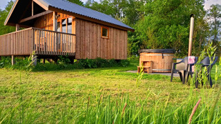 Cabane en bois avec véranda et bain à remous extérieur à Ackerlodges Ruinerwold BV, parc de vacances à Drenthe, Pays-Bas.