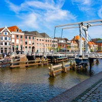 Canal pintoresco con casas históricas holandesas y puente levadizo en Ruinerwold, Drenthe, Países Bajos.